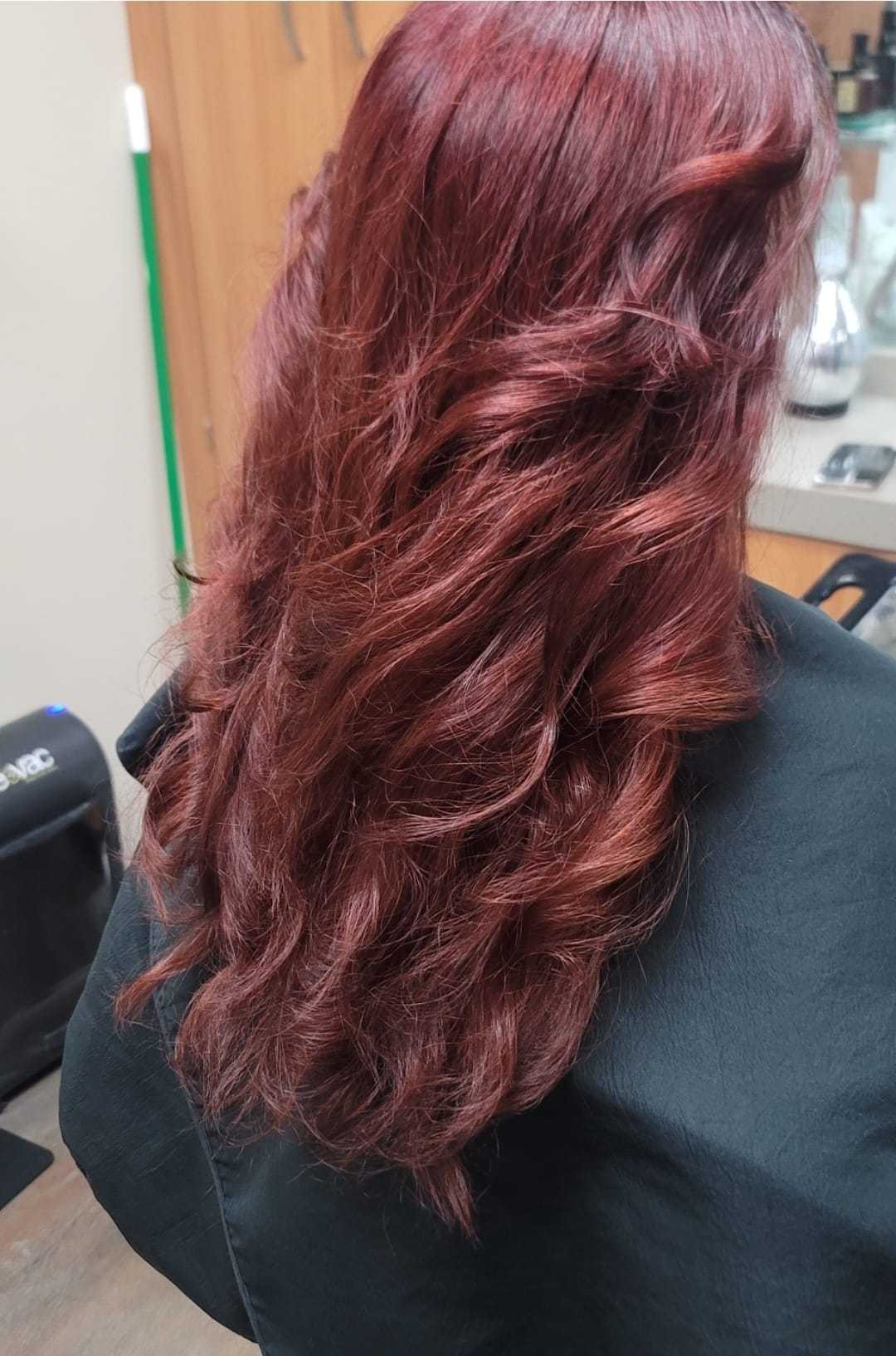 Red wavy hair styled elegantly on a salon chair.