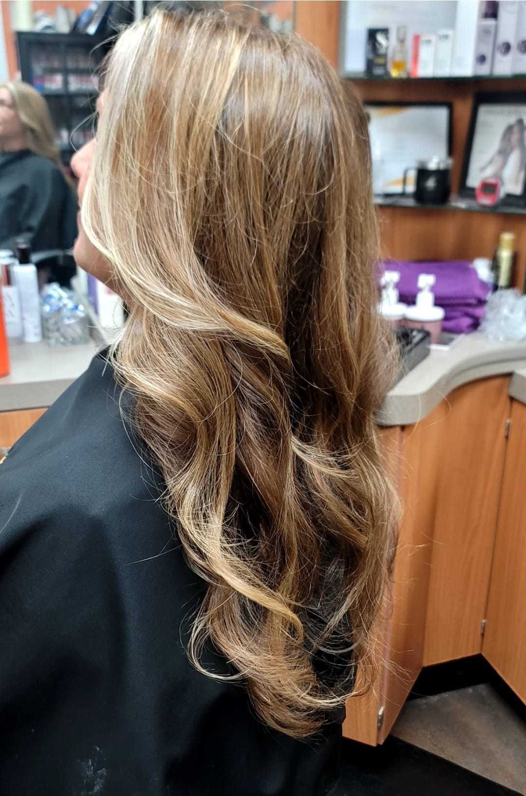 Woman with styled wavy hair at a salon.